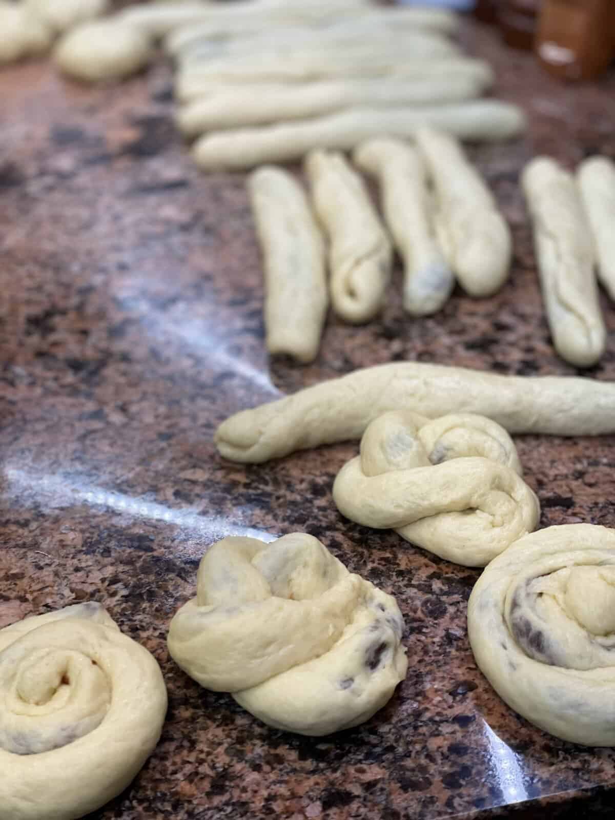 Dough filled with dates are being shaped to a brioche and ready to be baked.