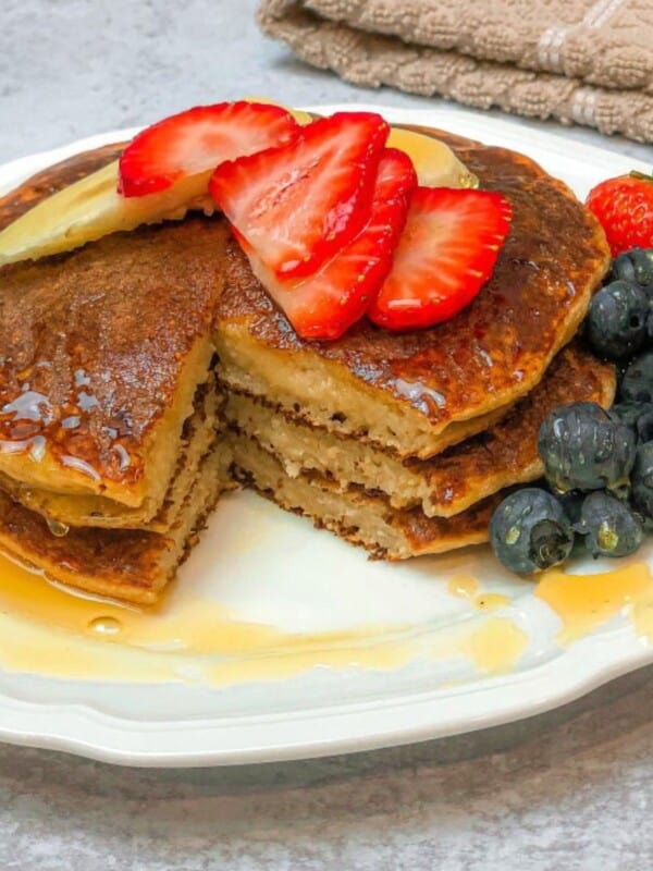 blender banana pancakes with strawberries on top and some blueberries on the side