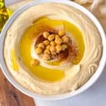 Vegan whipped hummus made with canned chickpeas, beautifully served in a white bowl.