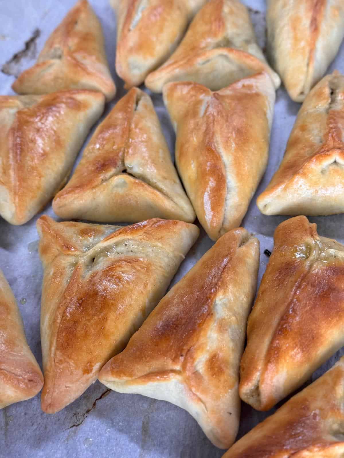 golden crusted lebanese spinach pies on parchment paper