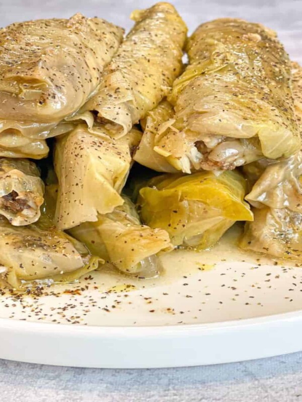 a dish of stuffed malfoof cabbage rolls sprinkled with dried mint