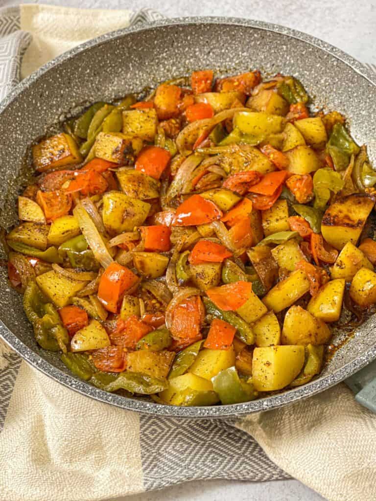 Skillet-Sautéed Potatoes and Onions is a great fried potato, peppers, and onion dish with a juicy tomato base that is packed with flavor!