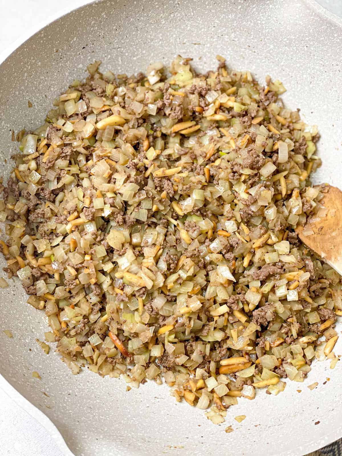 a well-cooked kibbeh filling made up of ground beef, onions, pine nuts, and slivered almonds, and seasoned with seven spices and salt