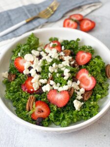 kale salad with pecan cranberries strawberries and Dijon vinaigrette