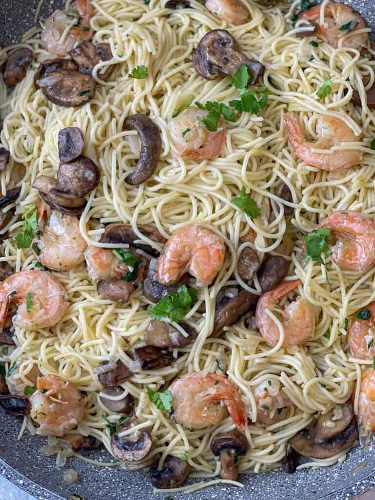 Mushrooms, onions, garlic, shrimp, and pasta come together with some cilantro garnish to make an amazing wine-free and easy shrimp scampi that is delicious