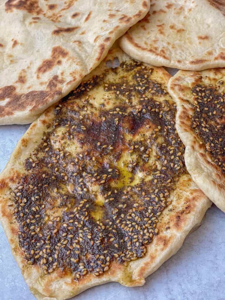 Manakeeh za'atar are tasty flatbreads from the Levantine region topped with olive oil and za'atar. Aromatic oil and herbs give this bread loads of flavor, making it a perfect snack..