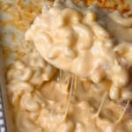 A hearty dish of macaroni and cheese with a creamy, rich cheese sauce, featuring a perfectly browned and bubbly cheese topping. The pasta is well-coated, and the dish looks golden and appetizing.