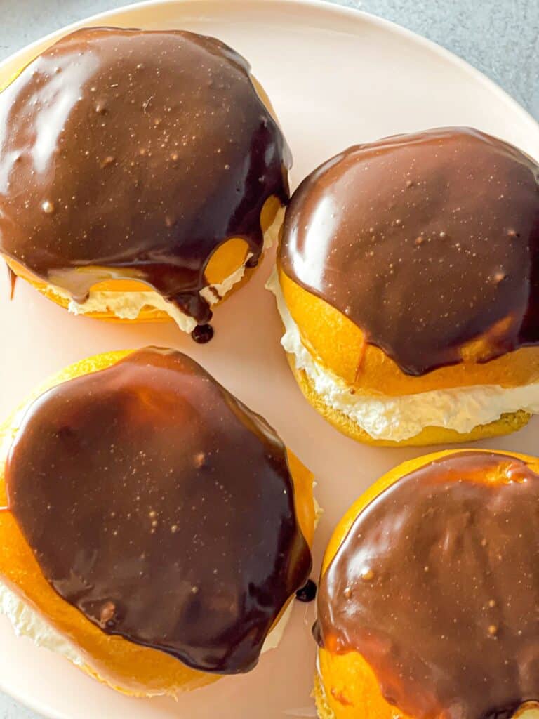 These soft and sweet Boston Cream Buns are filled with light whipped cream and topped with chocolate ganache. They are a real treat!