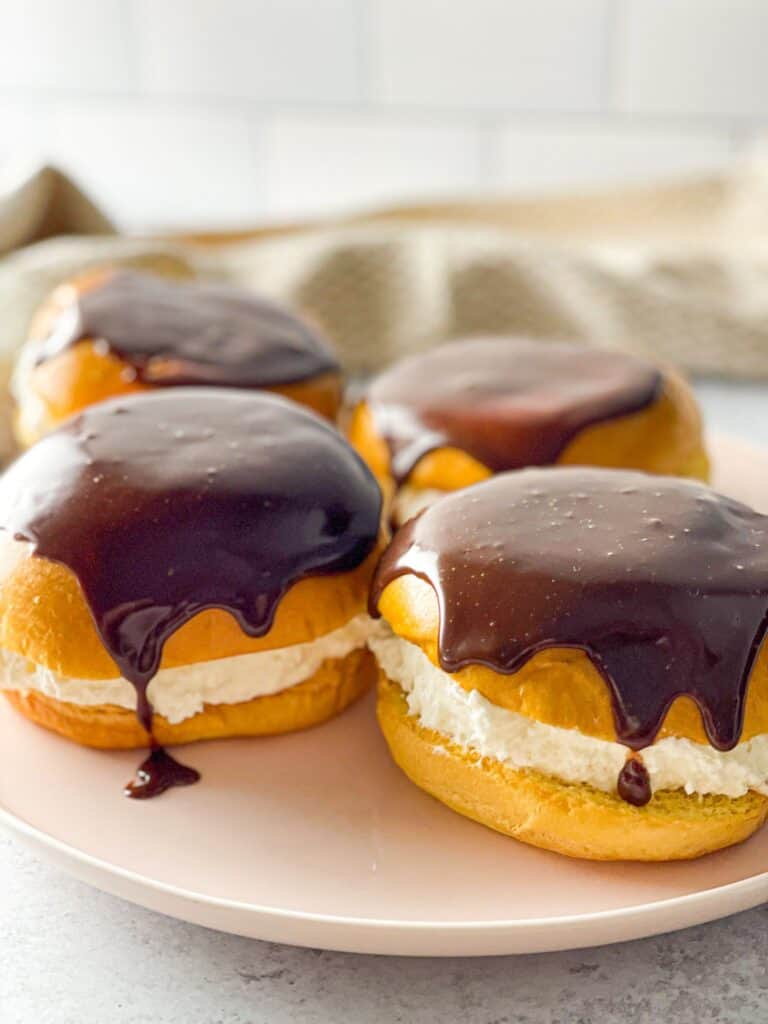 These Boston Cream buns are a heavenly dessert filled with luscious whipped cream and glazed with chocolate ganache.