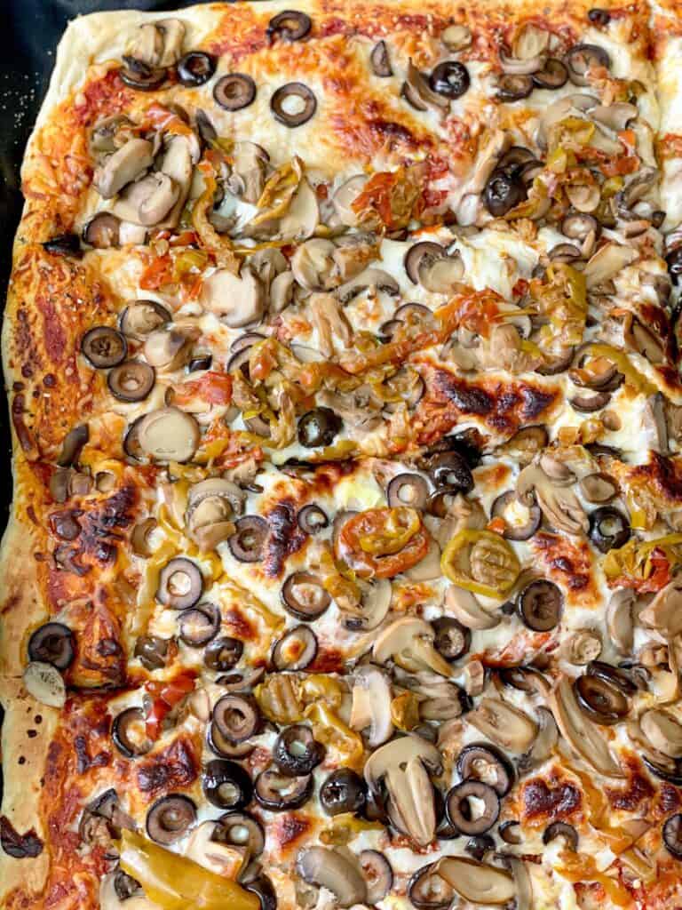 This homemade pizza dough recipe presents golden crust with melted cheese, and a variety of wild toppings.