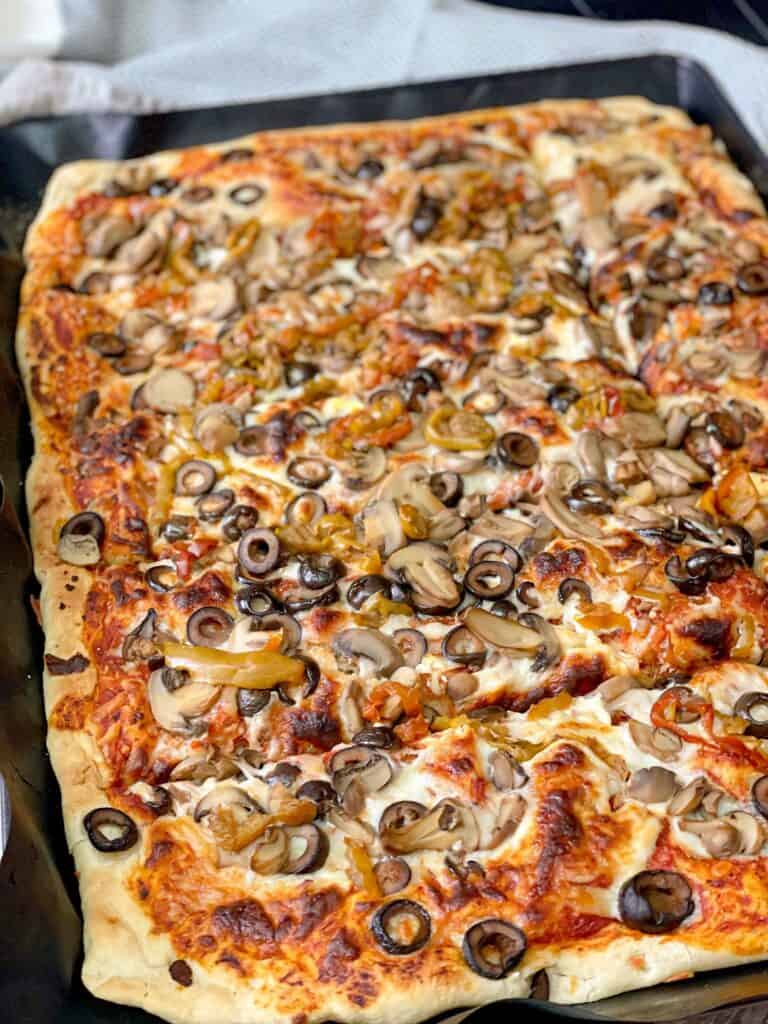 This Homemade pizza dough recipe is enough to feed and fill your family's hungry tummies. This pizza presents crispy golden crust with soft slices.