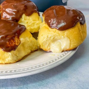 Tender chocolate Boston cream donuts filled with a silky vanilla custard and finish with a decadent chocolate glaze.