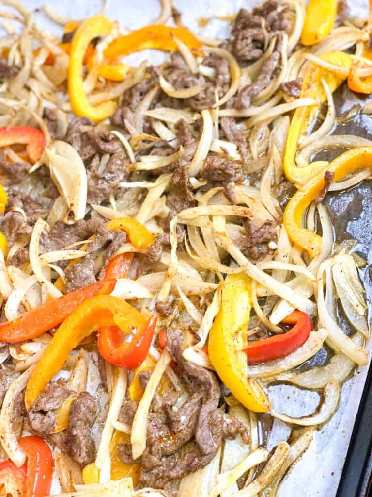 In the oven, toss the beef strips, onions and pepper slices on the sheet pan. Wait for 15 minutes. You will get the best fajitas ever!
