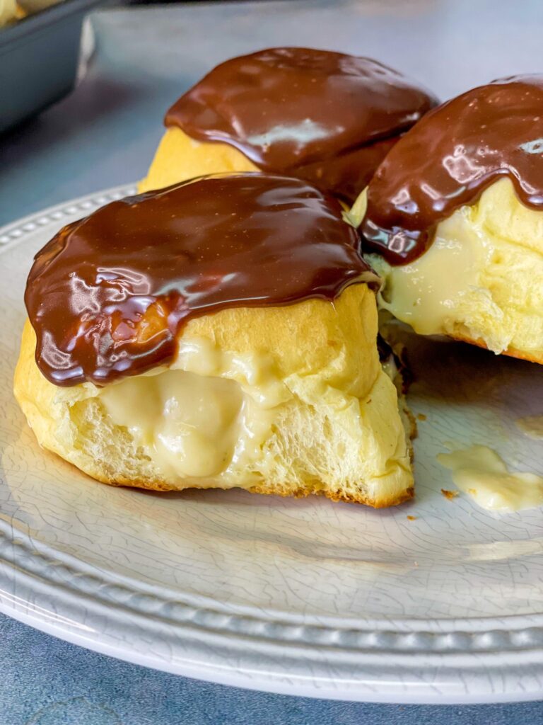 Soft, fluffy brioche buns filled with Boston cream and topped with a shiny chocolate glaze
