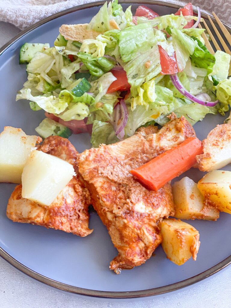 Deliciously baked, juicy and tender chicken breasts with a garlic, olive oil, yogurt, and tomato paste sauce served with salad.