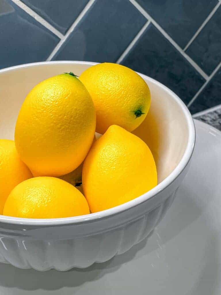 Fresh yellow lemons in a bowl are excellent to store in your freezer for a long time. You csn also store limes in the same container. 