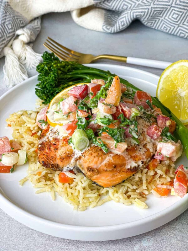 A delectable flakey baked salmon on a bed of Cajun rice with a zesty and tangy side Tahini salad