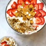A heavenly dessert featuring layers of creamy cheesecake topped with strawberries and s'mores.