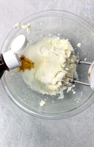 adding some vanilla to the cream cheese frosting before combining the ingredients with a hand mixer