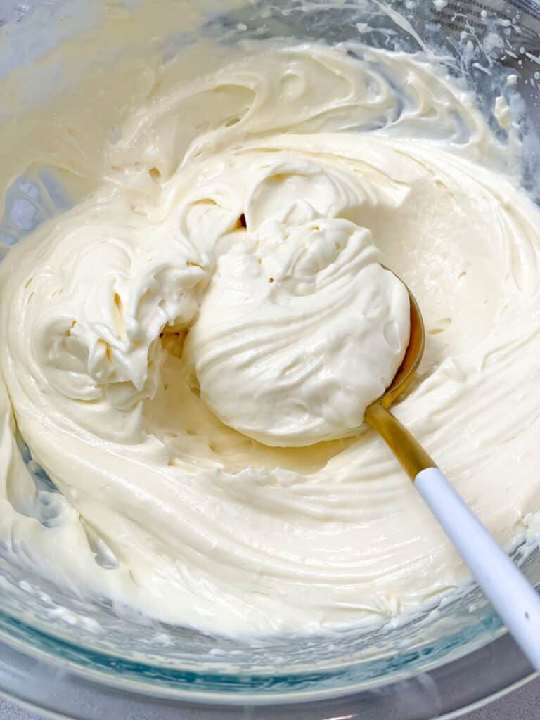 A bowl of cream cheese frosting is so soft and fluffy.