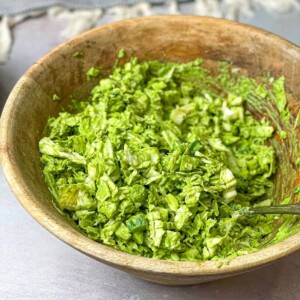 A bowl of green salad with creamy green dressing.