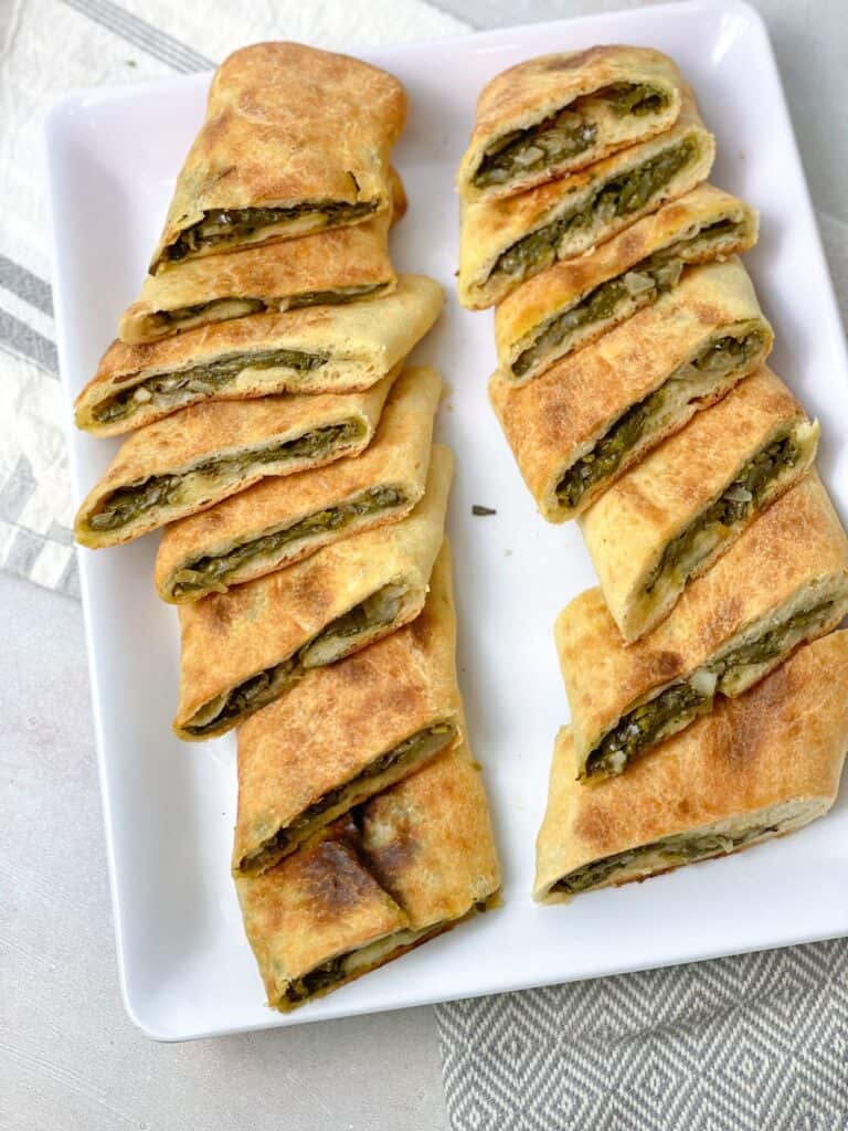 Spinach Pie cut into bite-sized pockets served and ready to be eaten.