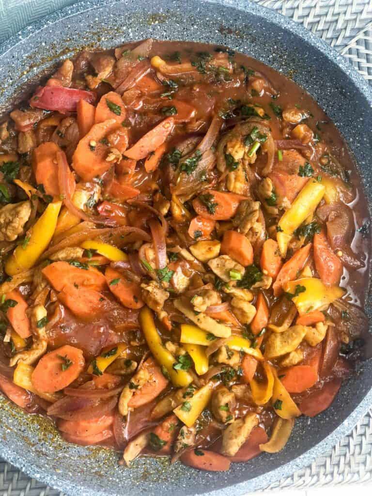 Enjoy a colorful dish of ghallaba and vegetables simmered in vibrant tomato sauce
