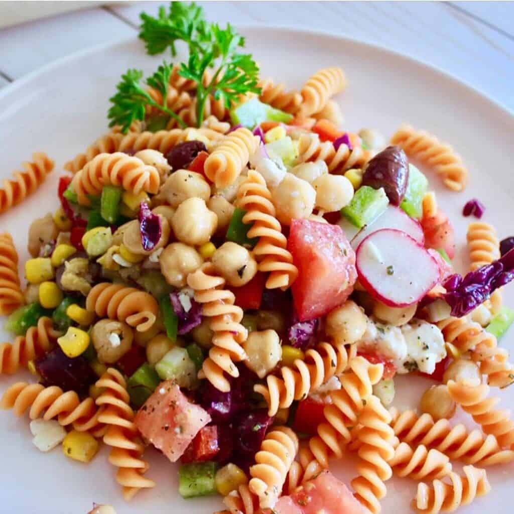 This Greek Pasta Salad introduces a mix of ripe juicy tomatoes, crisp pepper, cucumbers, and olives tossed with pasta, feta cheese, and a homemade lemony garlicky dressing! 