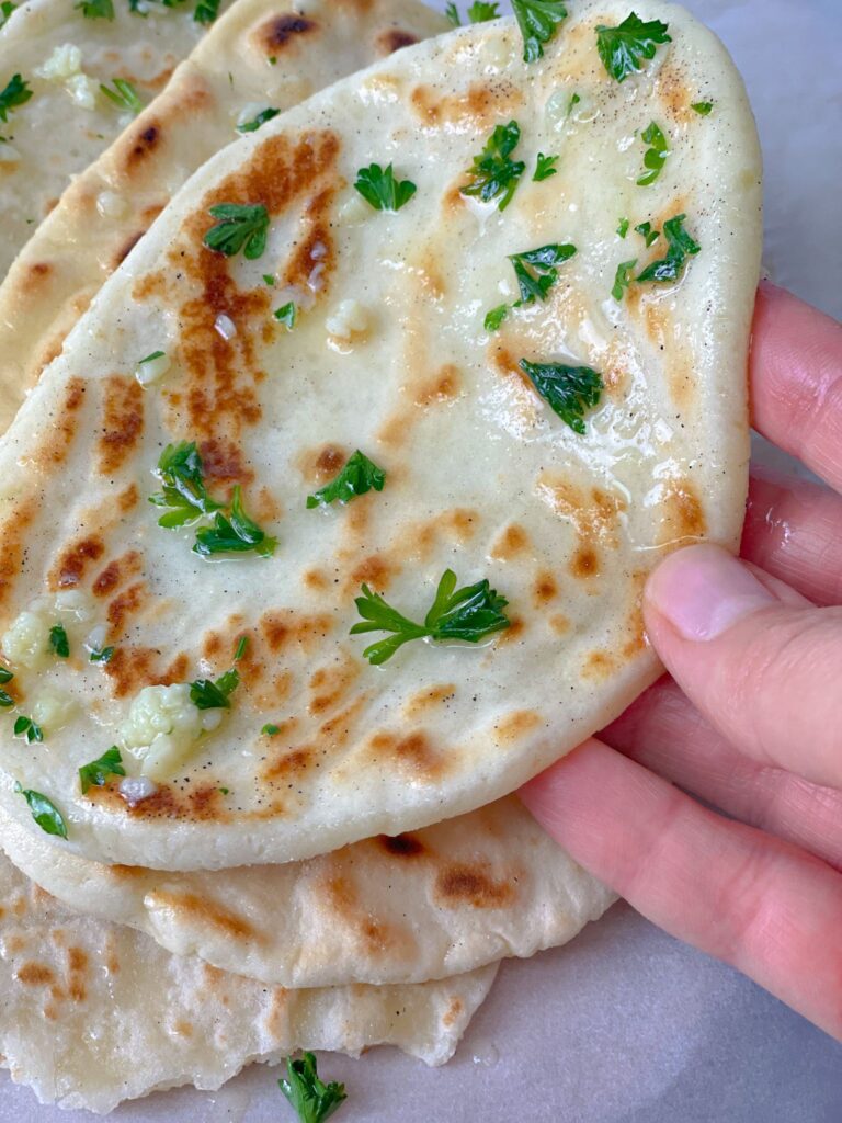 soft, pillowy, and garlicky naan bread ready to serve with your favorite soup or stew