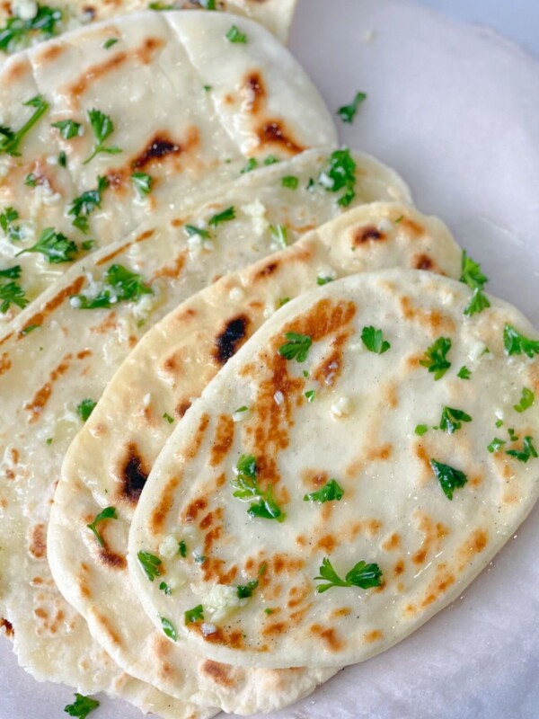 5 gluten free yeast free naan breads garnished with cilantro, butter, and garlic