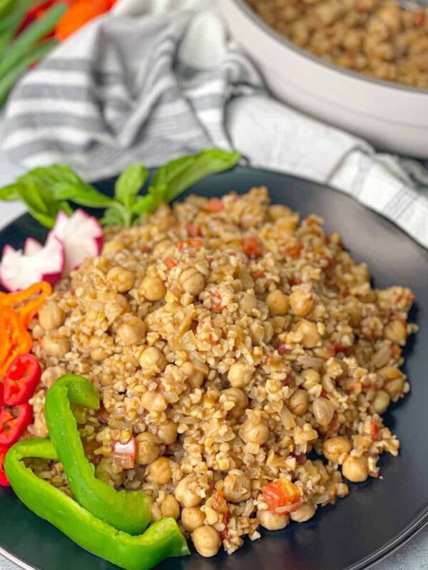 Vegetarian Bulgur and tomato pilaf served with bell peppers, radishes and fresh mint