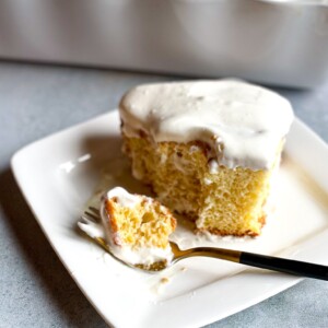 tender and fluffy sponge cake soaking in 3 milk syrup and topped with whipped cream in a plate