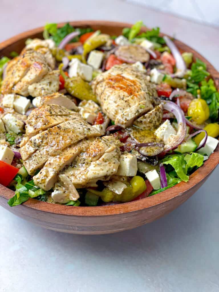 A healthy bowl of Greek salad and grilled chicken