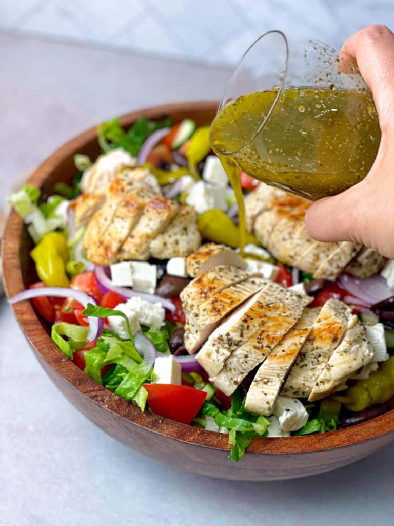 Pour the Greek dressing on top of the salad bowl and enjoy the taste