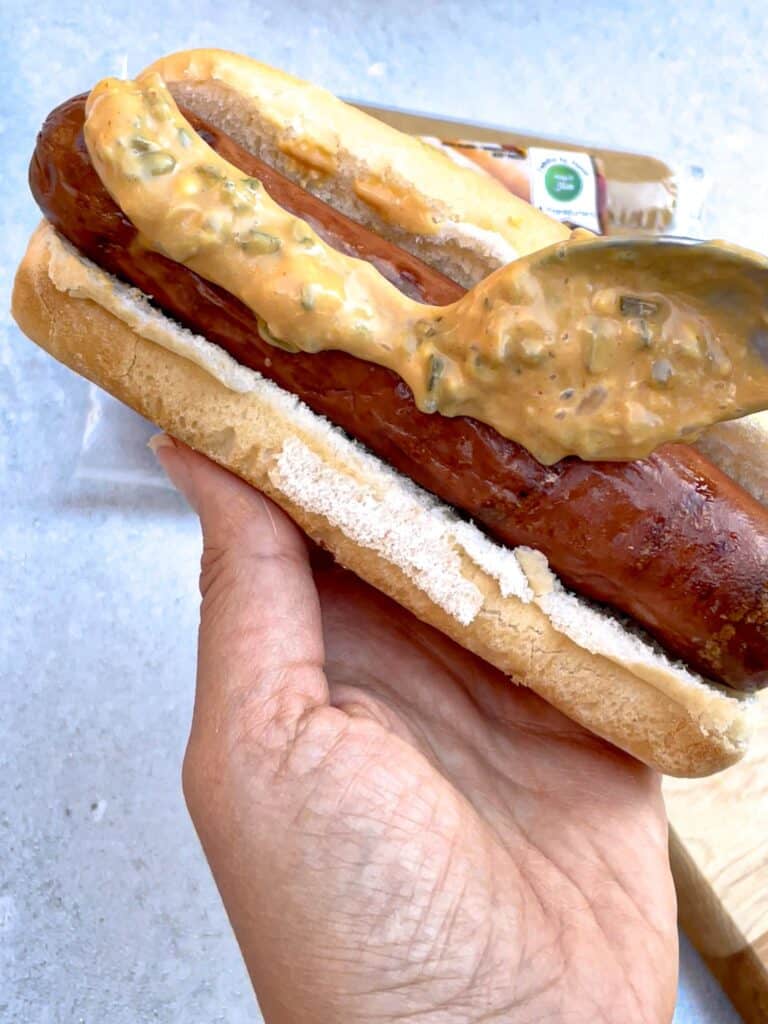 A hot dog sandwich topped with savory homemade sauce