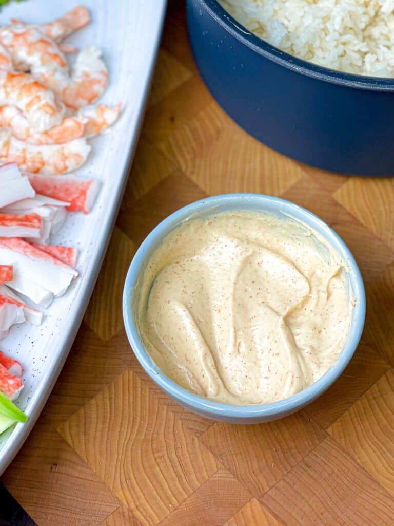A bowl of sushi sauce made of mayonnaise, butter, paprika, garlic powder, soy sauce and sugar s perfect to dip you sushi in