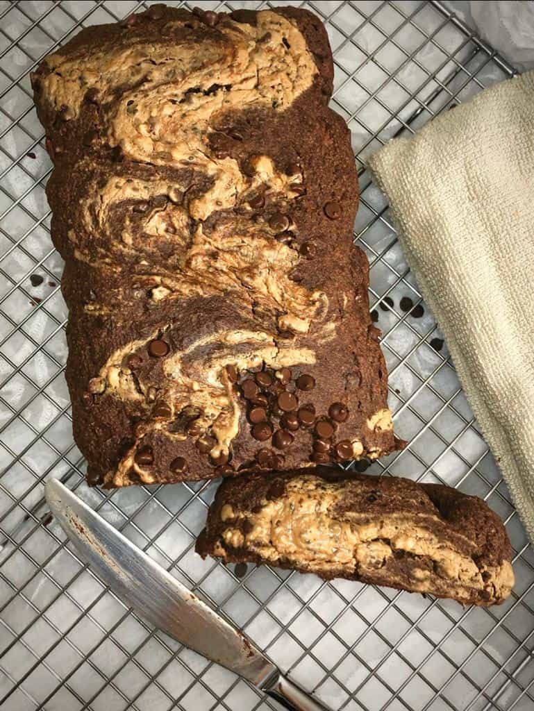 A loaf of double chocolate banana bread topped with chocolate chips has all the sweet flavors that the heart craves.