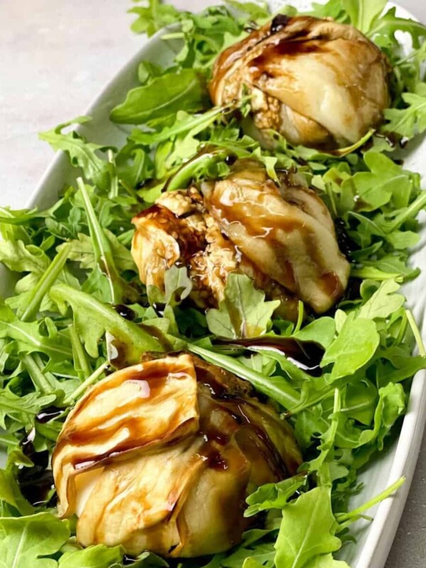 A beautiful platter of burrata wrapped with tender eggplants on the arugula layer and glazed with balsamic reduction.