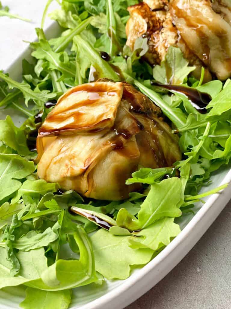 a beautiful burrata ball wrapped with tender eggplants on the arugula layer and glazed with balsamic reduction
