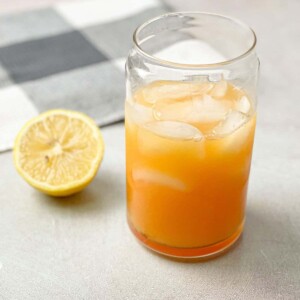 A glass of cold electrolyte made of lemon, orange, Himalayan salt, and honey.