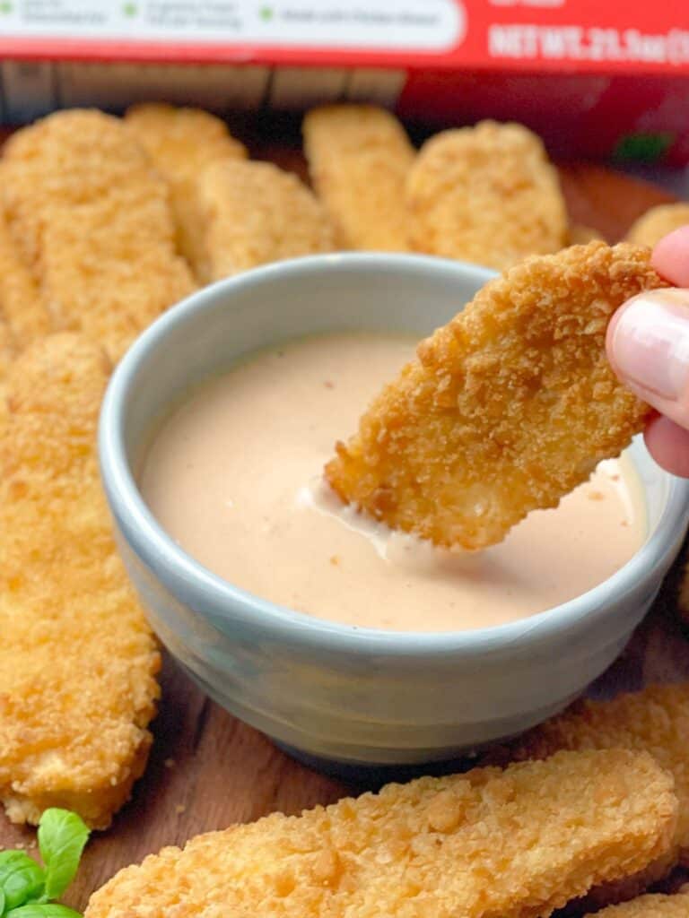 A bowl of chicken finger dipping sauce served with a side of chicken fingers