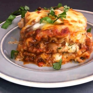 A generous piece of lasagna made up of layers of cheese, red sauce, meat, and lasagna noodles.