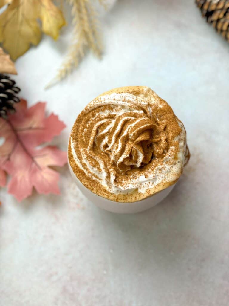 This homemade PSL is topped with whipped cream and cinnamon and served with your favorite snacks.