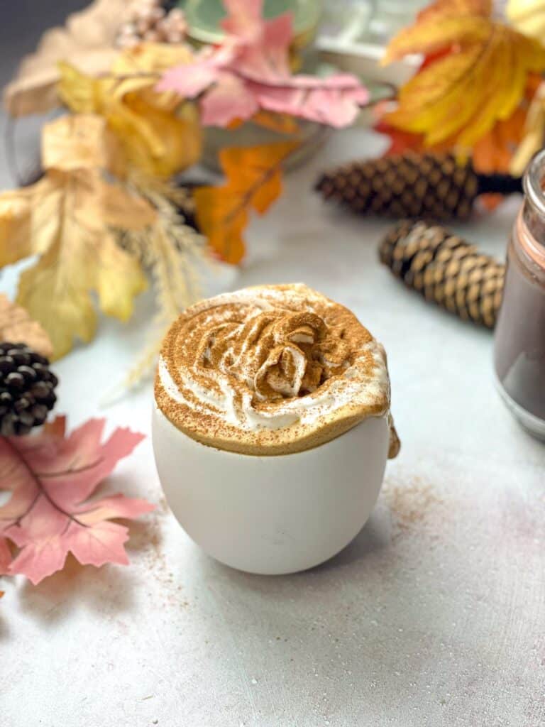 This dairy free pumpkin spice latte is made with simple plant-based ingredients like oat milk, sugar, and pumpkin spice blend, and topped with whipped cream and cinnamon.