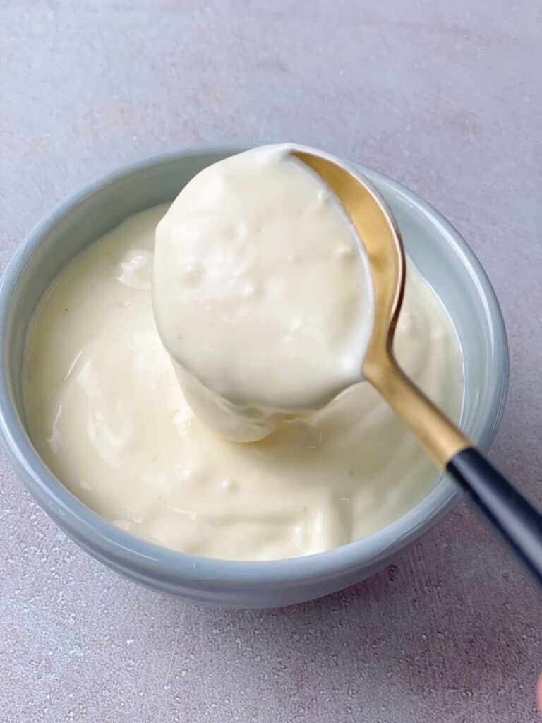 A bowl of creamy garlic aioli sauce made of mayo, lemon juice, garlic, olive oil, and salt