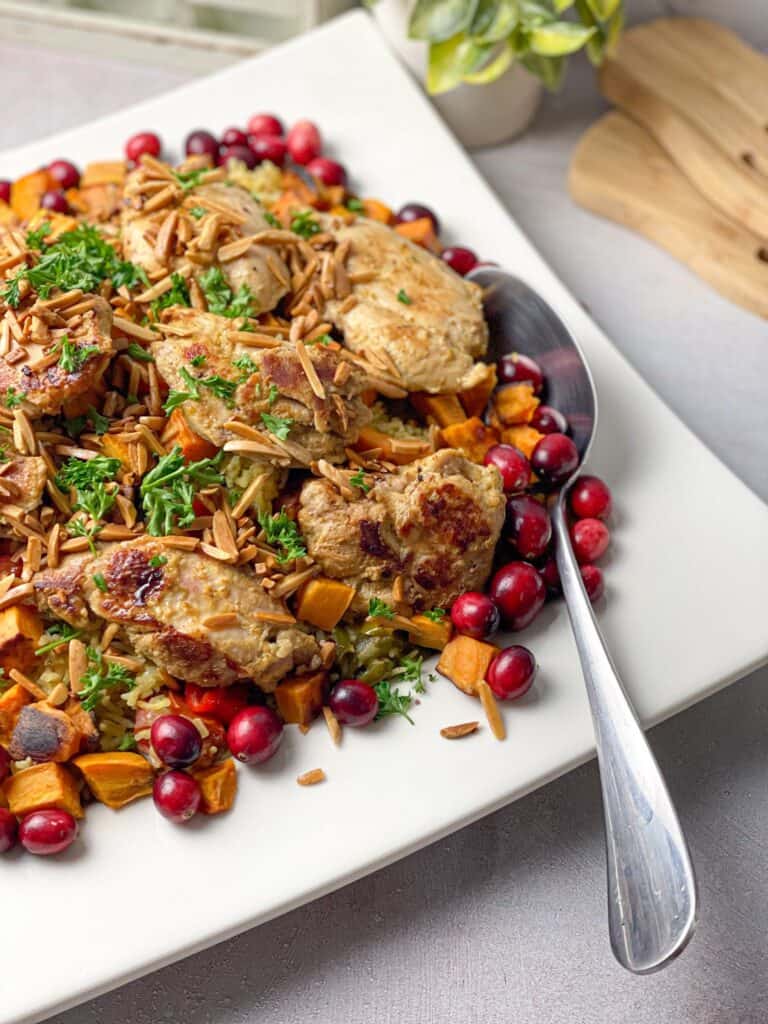 Layered Rice Veggie Pilaf with Chicken Thighs served with sweet potatoes and crunchy cranberries