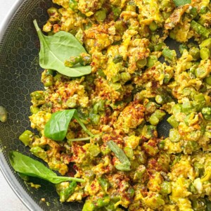 asparagus and eggs skillet garnished with paprika and served with fresh basil leaves