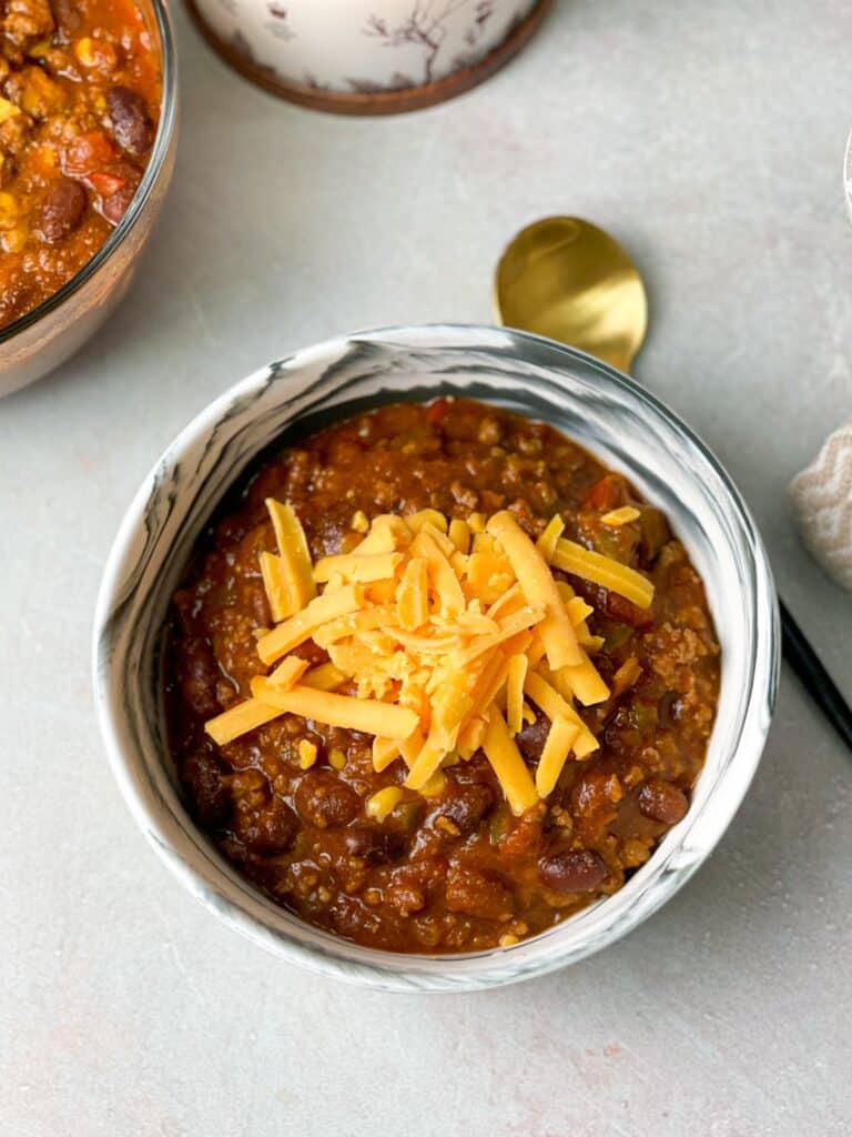 perfect bowl of chili topped with shredded cheddar cheese