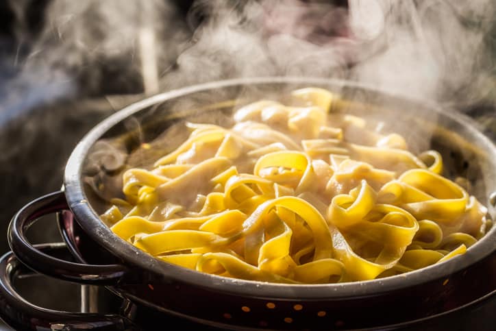 Steaming strainer of noodles after it being reheated.