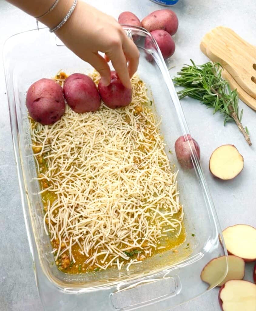 Placing the potato halves face down in the baking sheet